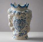 Ceramic vase with blue decorative patterns on a wooden surface