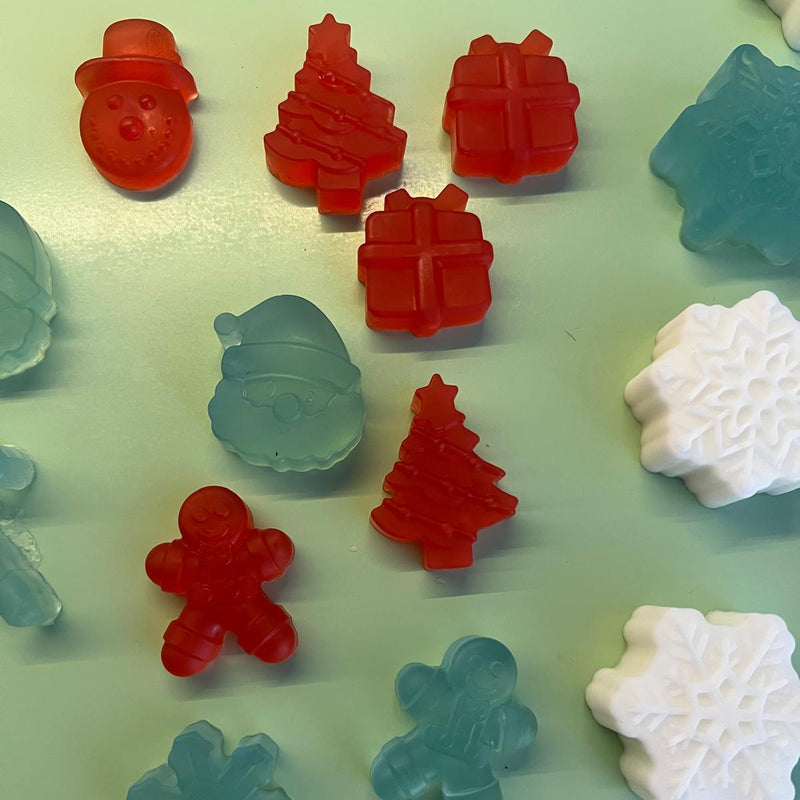 Assorted Christmas-themed gummy candies on a light green background